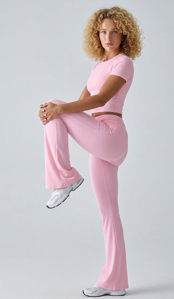 Woman in pink athletic outfit posing against a light gray background