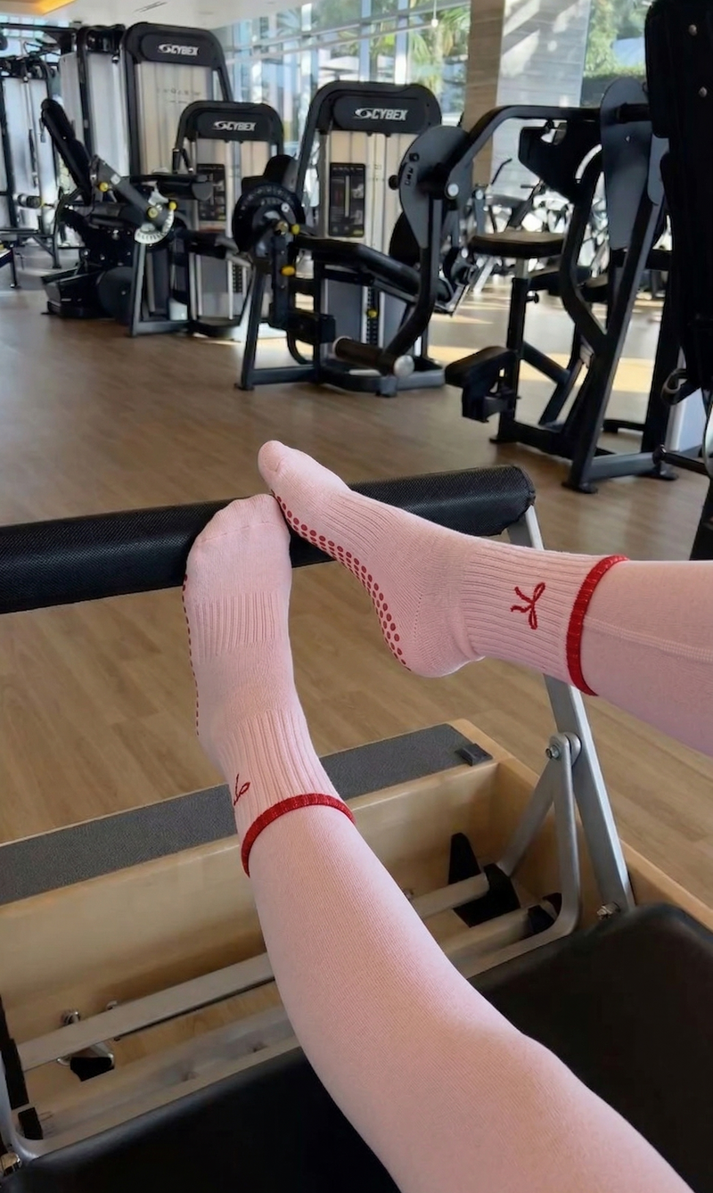 Person wearing white socks with red accents in a gym setting